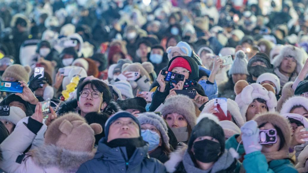 1月5日，在哈尔滨冰雪大世界园区，游客观看第40届中国·哈尔滨国际冰雪节开幕式。 新华社 图