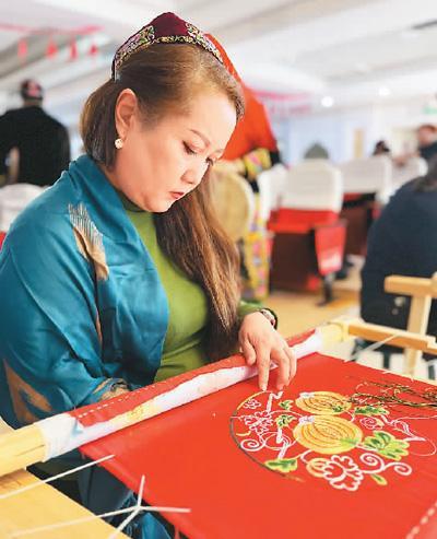 卡德尔团队的绣娘在制作哈密瓜图案的刺绣作品.本报记者 孙 懿摄