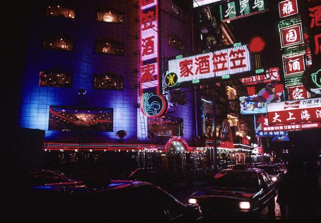 1998年10月,上海黄河路,店铺的霓虹灯招牌林立,马路上停满了汽车.