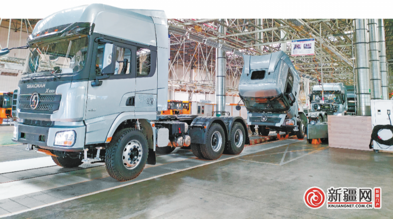 在陕汽新疆汽车有限公司的生产车间，一辆辆重卡汽车即将下线。（全媒体记者唐红梅摄）