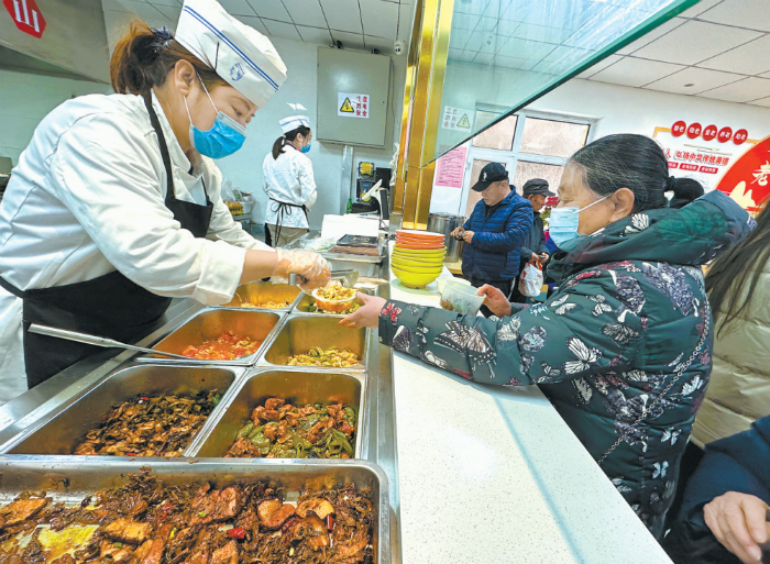 工作人员正在为居民打菜