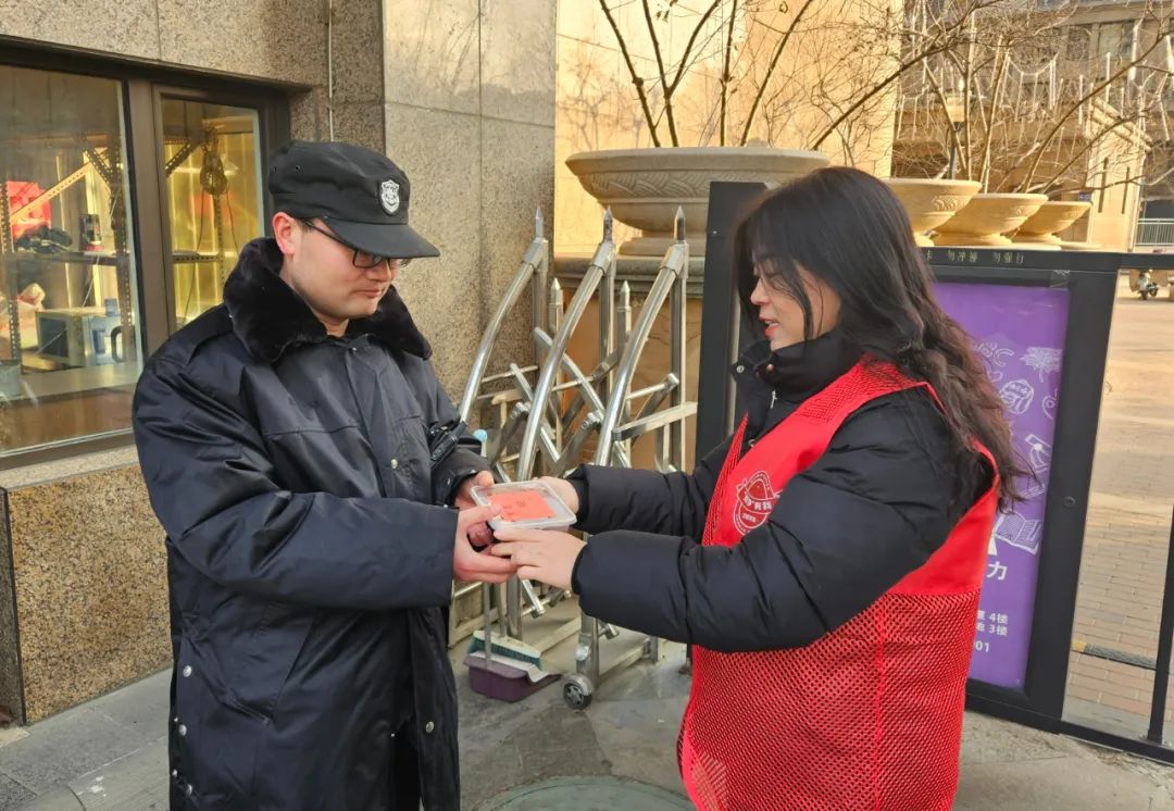 社区工作人员将腊八粥送到外卖小哥,保安等人手上.通讯员 黄希瑶 摄