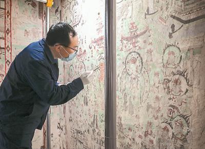 在敦煌莫高窟第55窟内，文保工作者对壁画进行修复。 新华社记者 李 贺摄