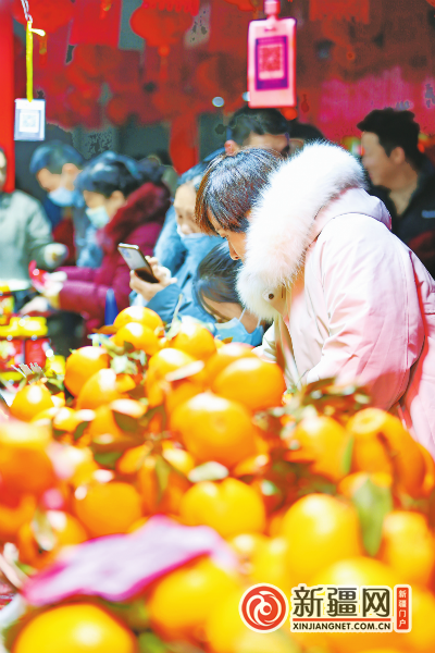 市民在第十六届新疆新春年货博览会上选购广西冰糖橙。（全媒体记者迪丽娜尔·加力肯 实习记者雷婷摄）
