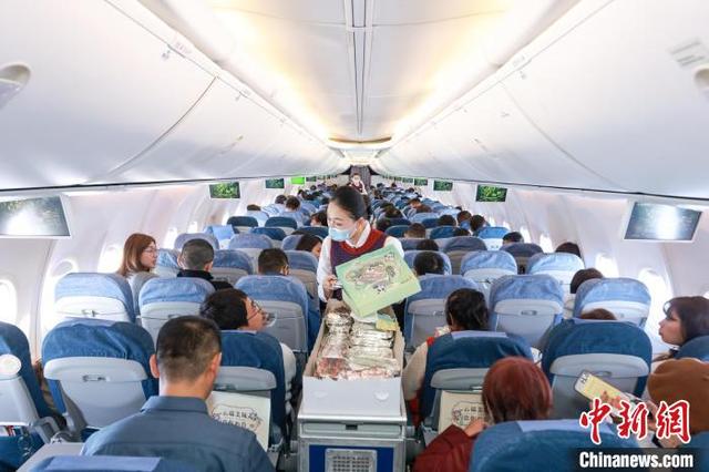 1月28日，从厦门至北京的国航CA1832次航班接近满员，乘务员在机舱内提供餐食。记者 贾天勇 摄