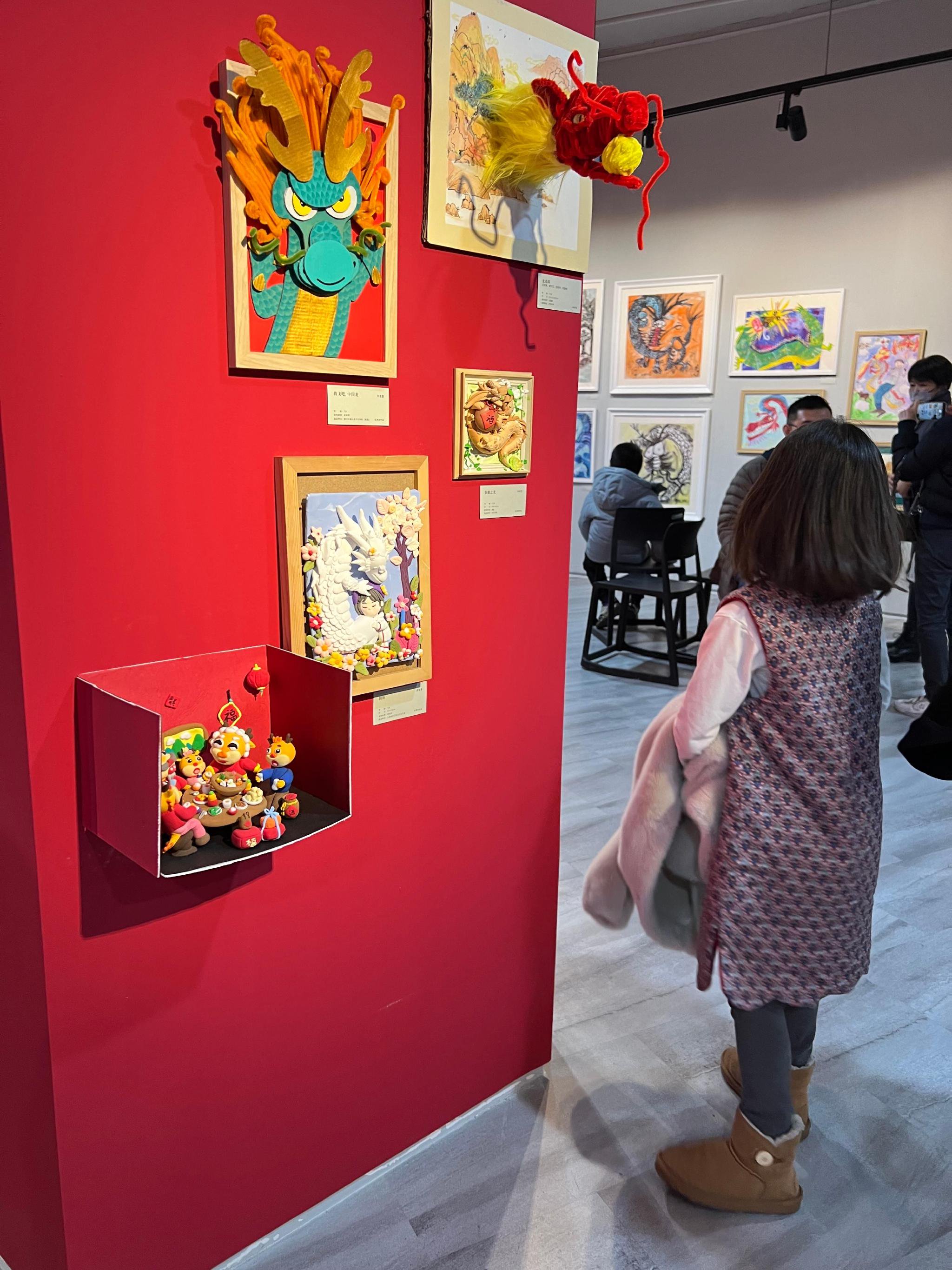 小小策展人吴小天把作品《龙子龙孙迎龙年》(左下)布展到适合小朋友观