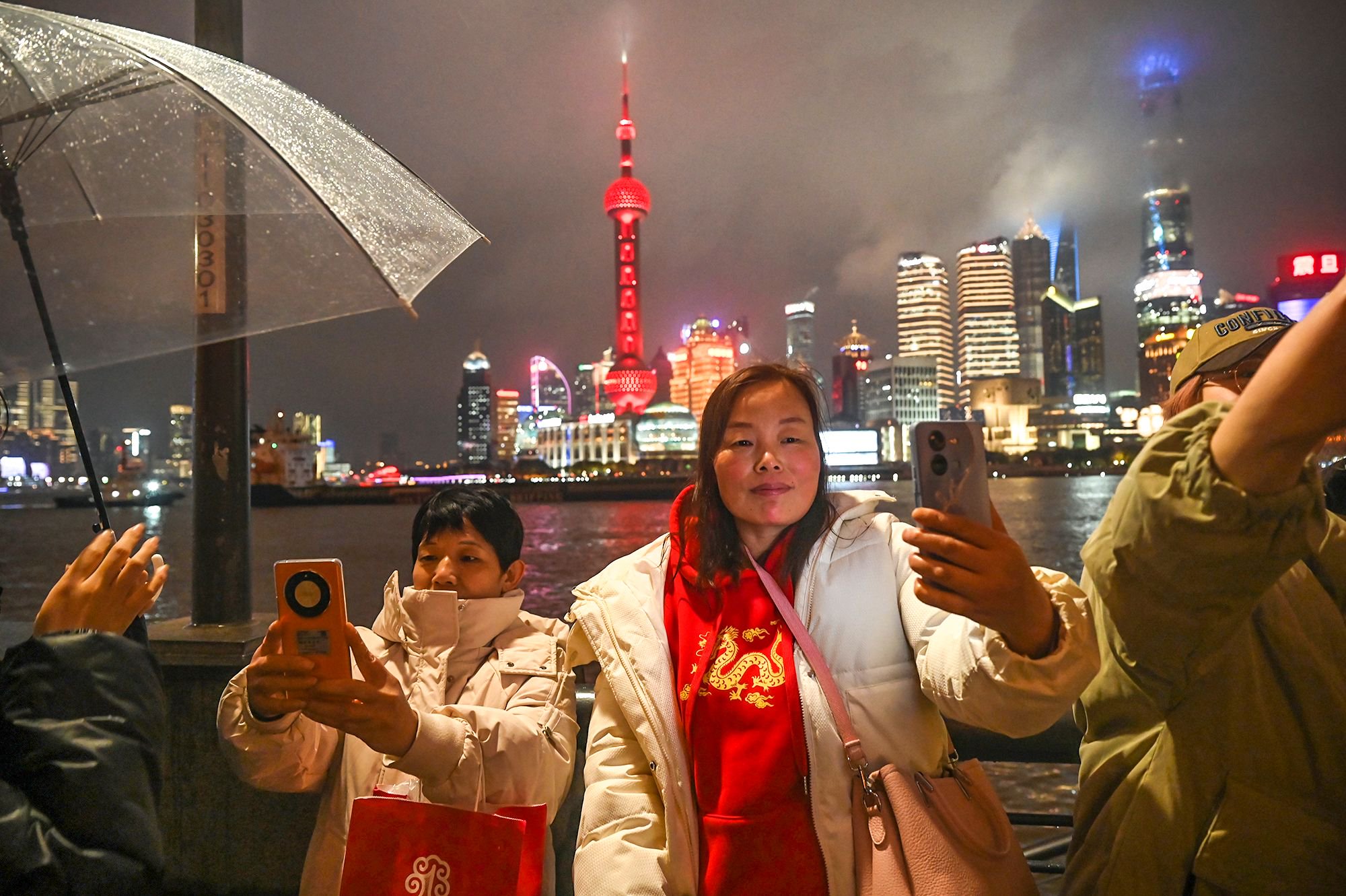 2024年2月1日,上海.一位身着中国龙图案的女士在外滩边打卡自拍.