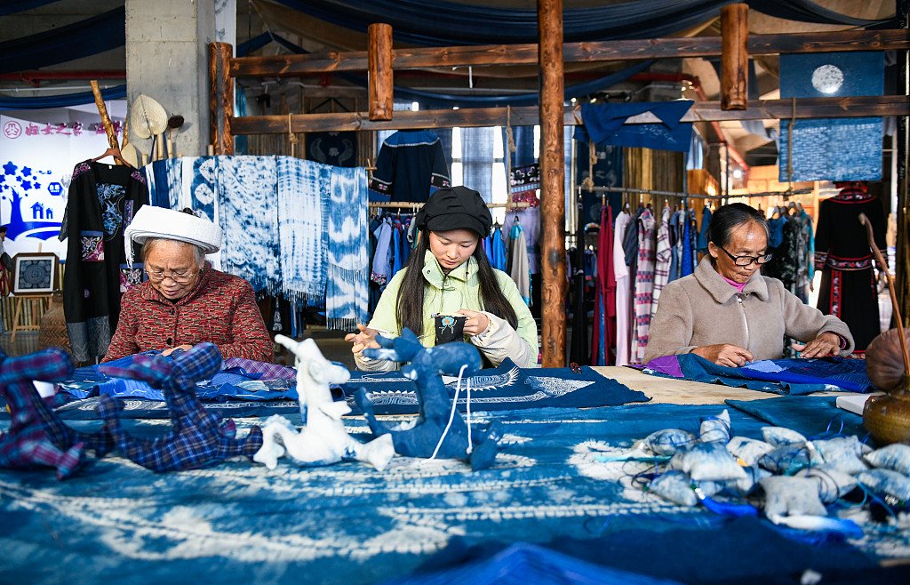 2024年1月10日,贵州黔西南,手工艺人赶制布依族龙年文创饰品.