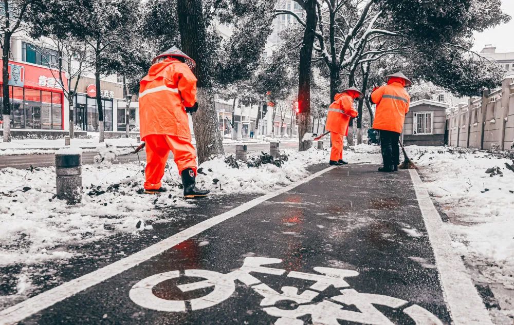 2月6日下午,环卫工人们在武汉市洪山区工大路上清扫积雪.