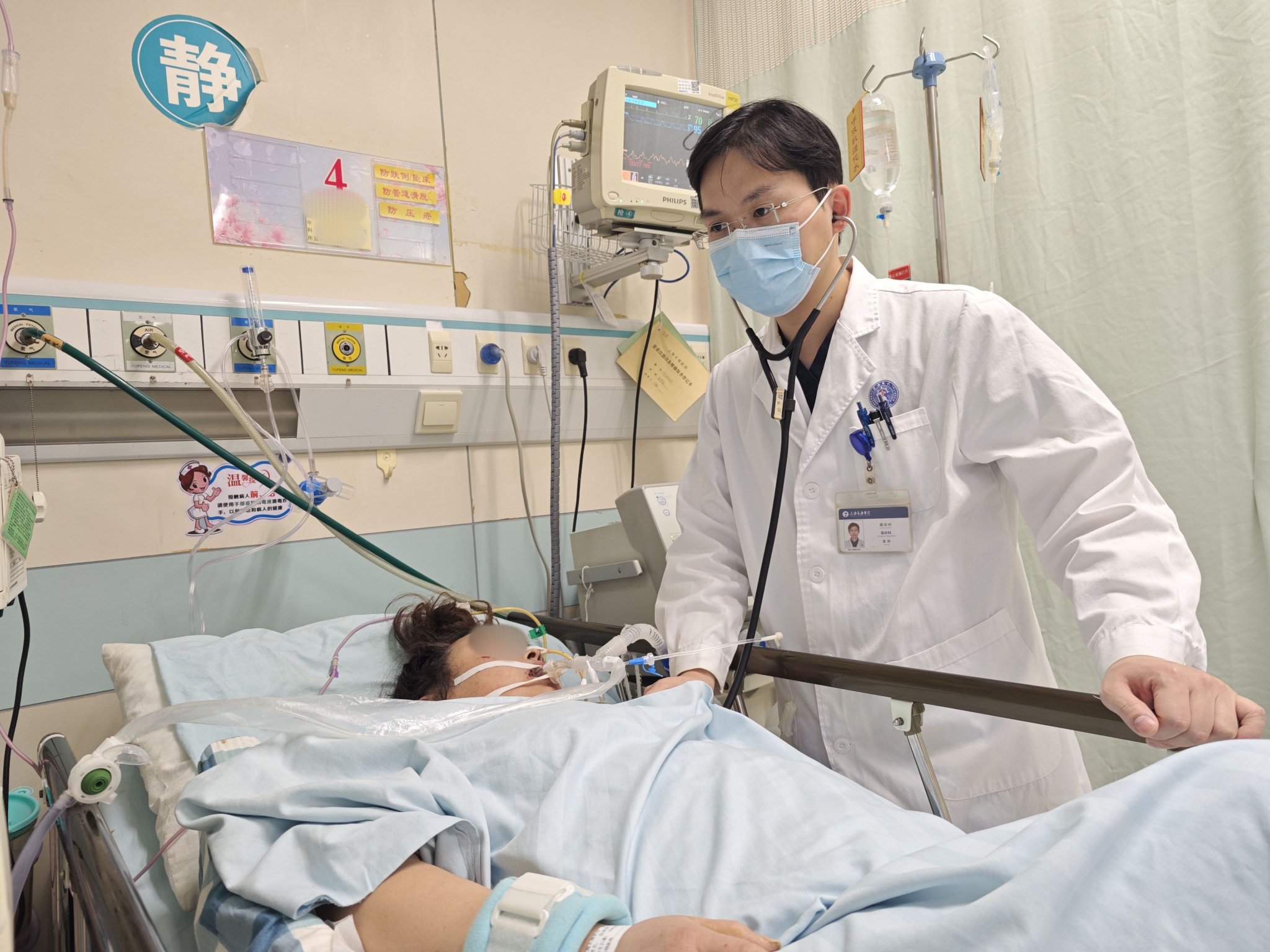 上海长海医院急诊科重症病房,梁云兴在检查病人情况.