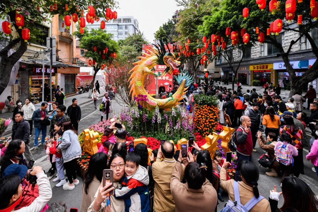 市民在2024越秀西湖花市位于教育路的花坛前合照留念.