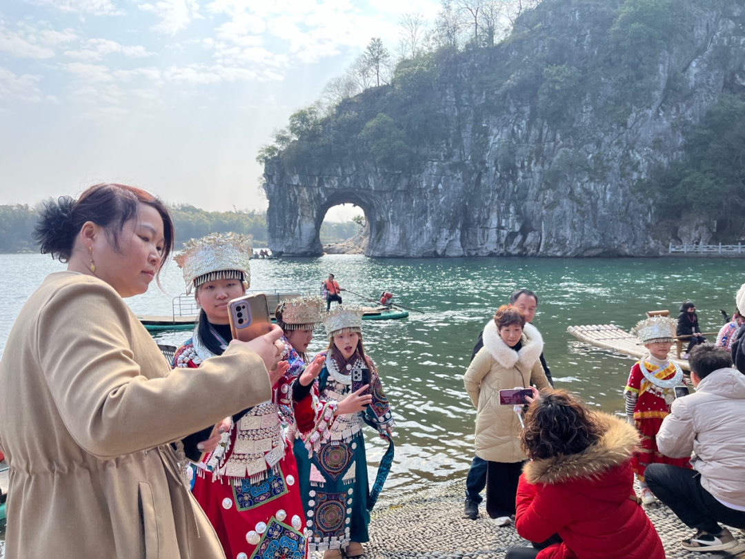 象鼻山景点前,穿着少数民族服饰的游客正在打卡拍照.周春媚/摄