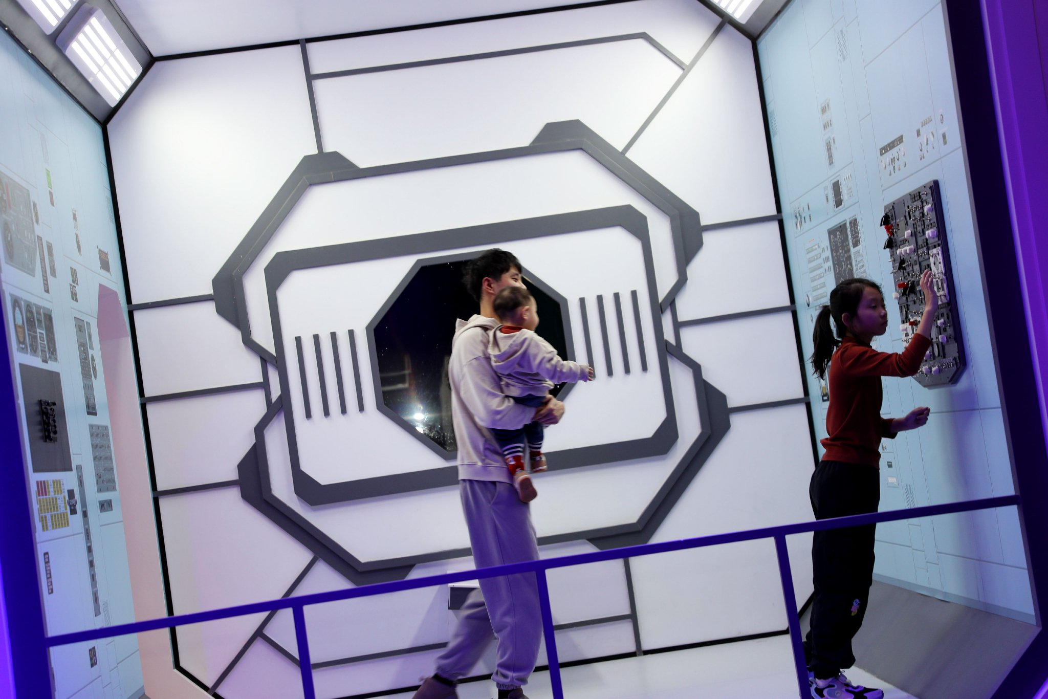 2月14日,在青岛西海岸科技馆,家长和小朋友在"空间站"模型内体验.