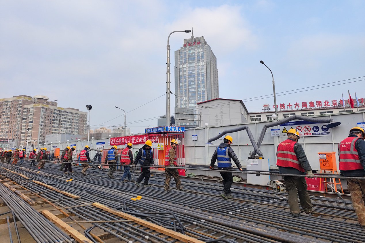 东大桥站项目施工人员搬运钢筋.