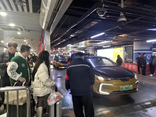 旅客乘坐出租车离站/记者拍摄