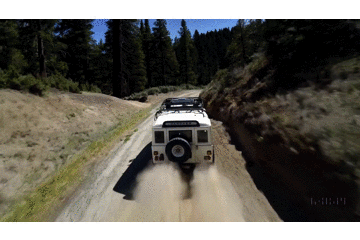 Sora生成的视频：白色SUV在陡峭土路上加速行驶，扬起灰尘。