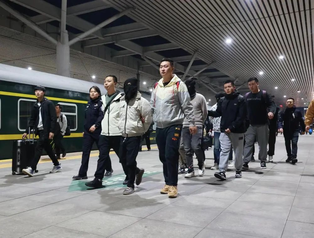 这是专案组民警在押解被抓获的犯罪嫌疑人.(杜星宇 摄)