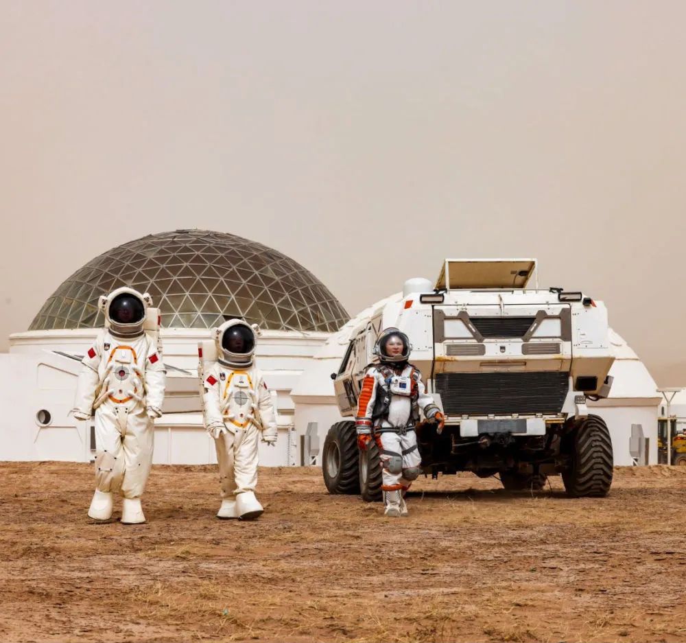 游客(右一)身穿"航天服"在甘肃省金昌市"火星1号基地"体验"漫步火星"