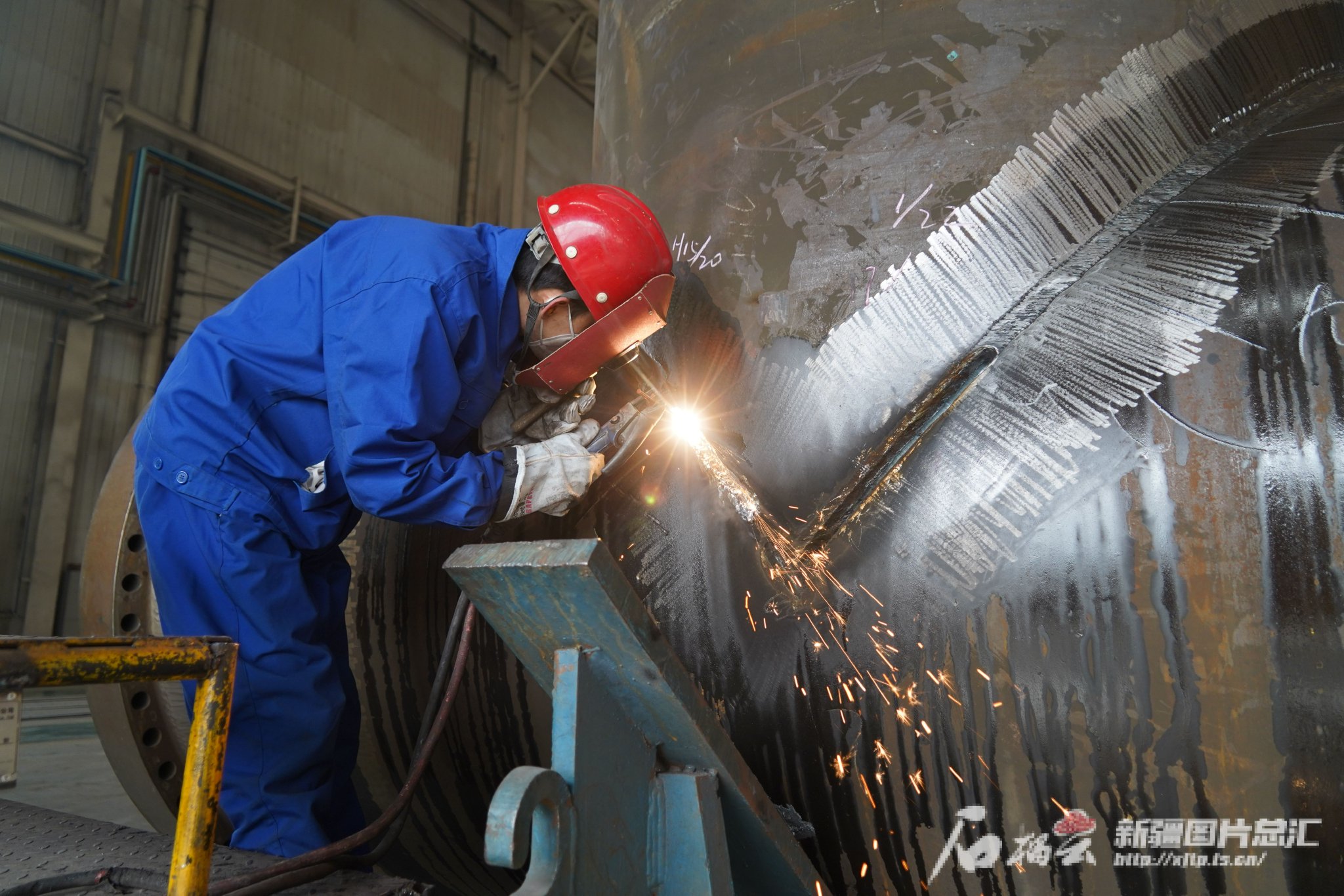2月21日，哈密高新技术产业开发区的新疆兰石重装能源工程有限公司生产车间里，工人正在对产品接口处进行打磨处理。郭子毅摄
