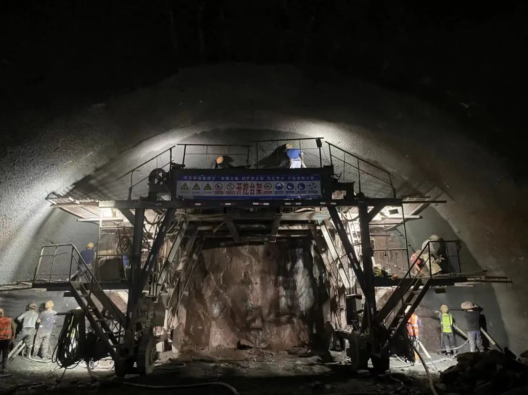 光明隧道现场施工人员打完炮眼后正进行工序转换