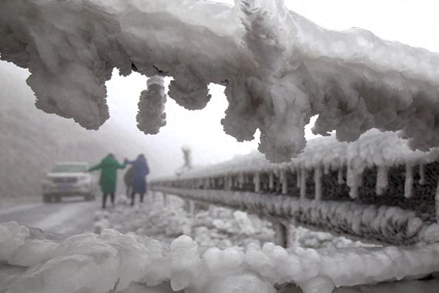 　　2024年2月7日，湖南衡阳，低温致雨雪在路面、物体及草木上快速冻结成冰凌。道路标志牌、风电站设备、公路护栏等都被裹上一层冰片。