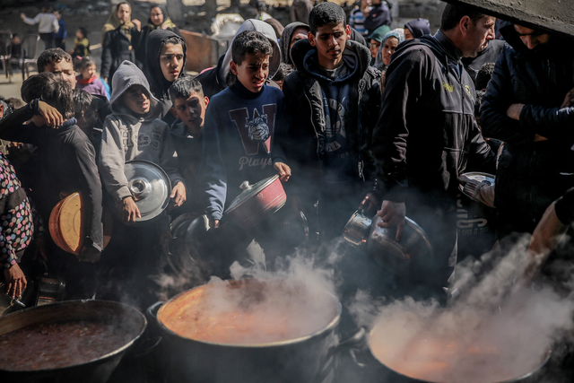 当地时间2月26日，在加沙地带北部的拜特拉希亚，巴勒斯坦人领取援助食品。图源：美媒