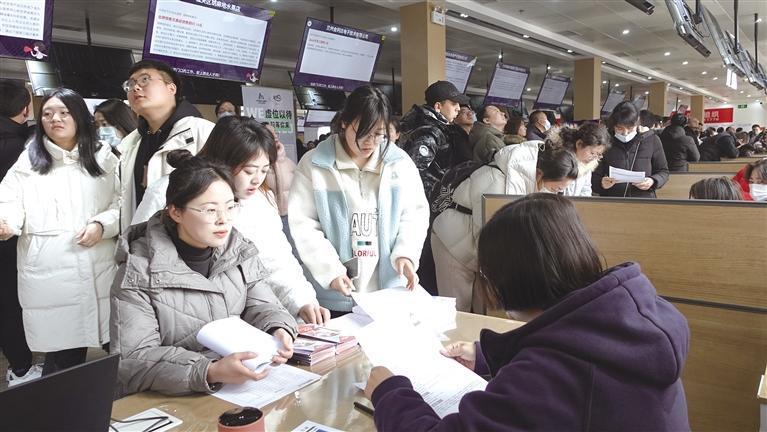 招聘会上求职者向招聘方了解情况