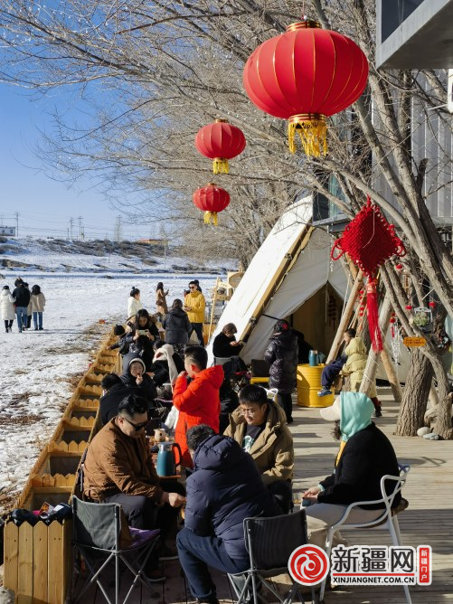 2月13日,在乌鲁木齐县永丰镇上寺村阡陌乡宿营地,游客正在体验围炉