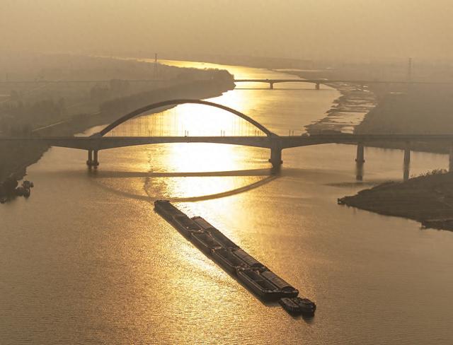 2023年11月12日,安徽淮南,淮河寿县段,夕阳下,货船航行在波光粼粼的
