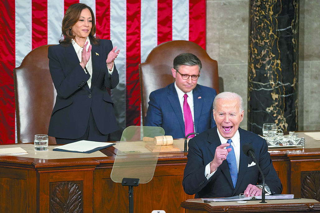 他的身后是副总统哈里斯和众议院议长约翰逊. (视觉中国)