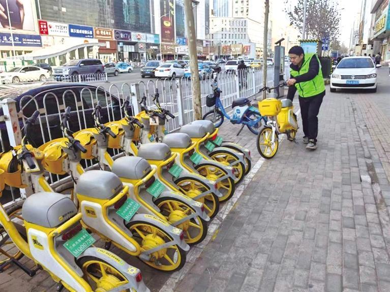工作人员摆放共享电单车
