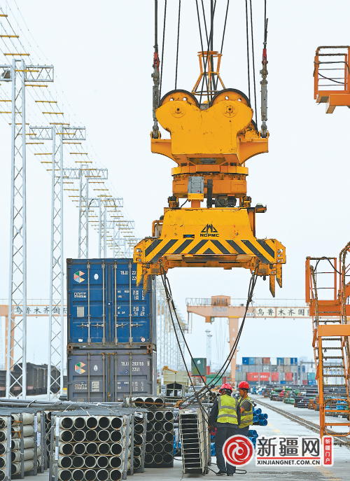 在乌鲁木齐国际陆港区中欧班列集结中心，大型机械设备正在向专列吊装货物。（乌鲁木齐晚报资料图片）