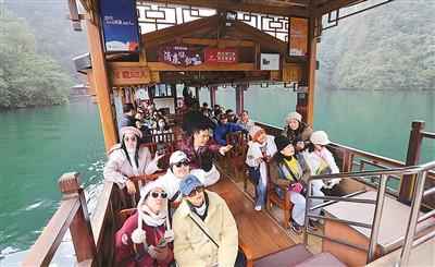 来自泰国、韩国的游客乘船在湖南张家界宝峰湖景区游玩。吴勇兵摄