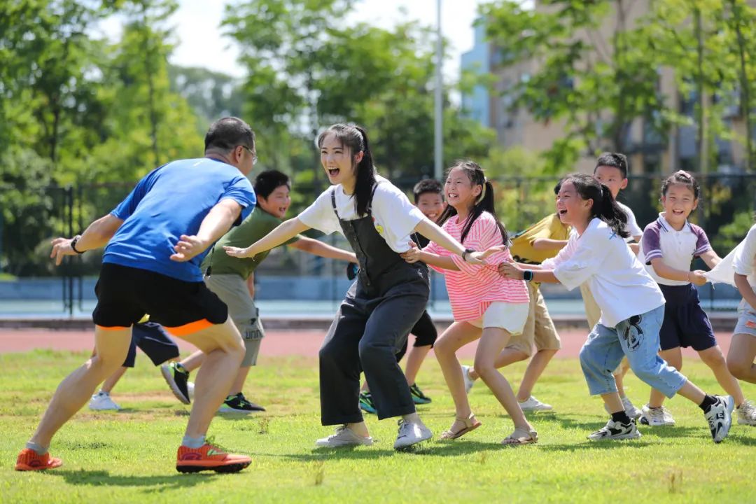 浙江省湖州市德清县三合中心学校,老师带着学生们玩老鹰捉小鸡的游戏.