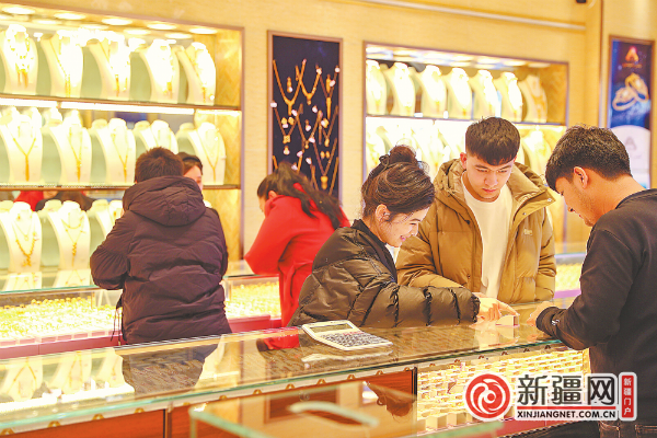 3月18日，顾客在天山区一家黄金店挑选金饰。（全媒体记者米热扎提·木塔力甫摄）
