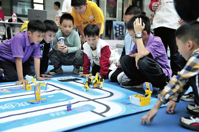 南宁市天桃实验学校校园科技节活动上,学校机器人社团的孩子向同学