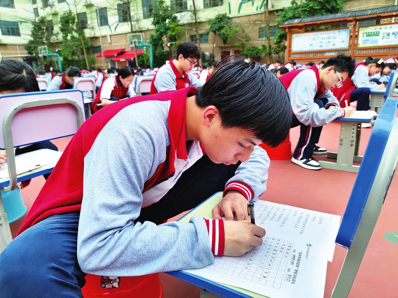 南宁市宏德高级中学举行"我用笔墨颂雷锋"主题千人硬笔书法大赛,学生