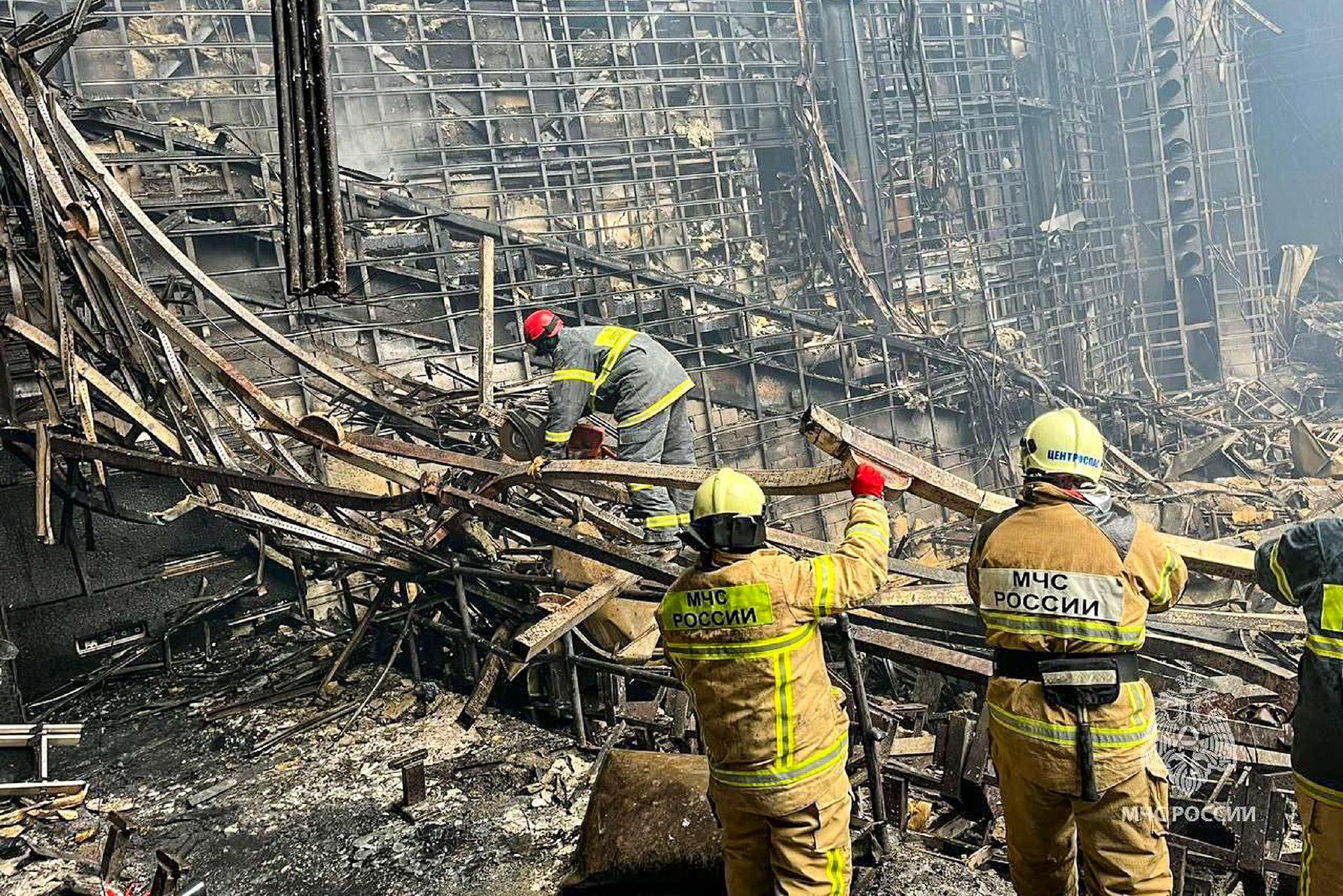 紧急情况部救援人员正在清理被烧毁的番红花市政厅音乐厅礼堂的废墟