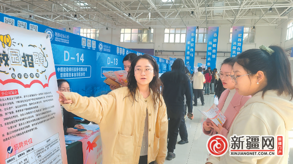 3月27日，在新疆财经大学举办的招聘会上，学生正和企业工作人员沟通岗位信息。（全媒体记者牟敏摄）