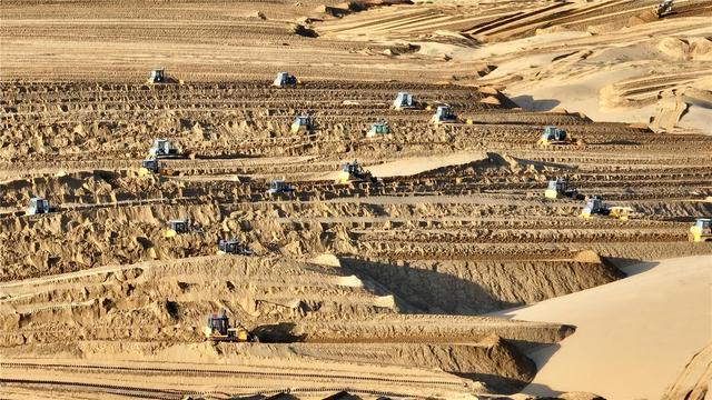 大型风电光伏一体化工程建设现场，正在进行沙地平整作业。杨耀中 摄