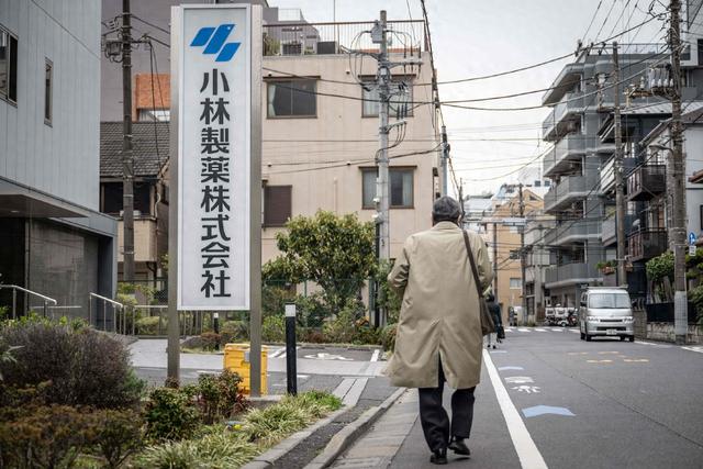 当地时间2024年3月28日，日本东京，一名男子走过小林制药公司办公室外的标牌。视觉中国 图