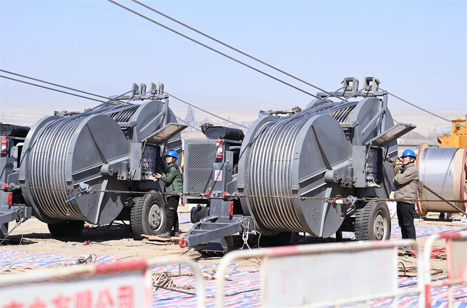 巴州-铁干里克-若羌750千伏线路工程第一个跨越作业顺利进行。图为在库尔勒市塔什店镇的两个张力场同时展放导线。马元 摄