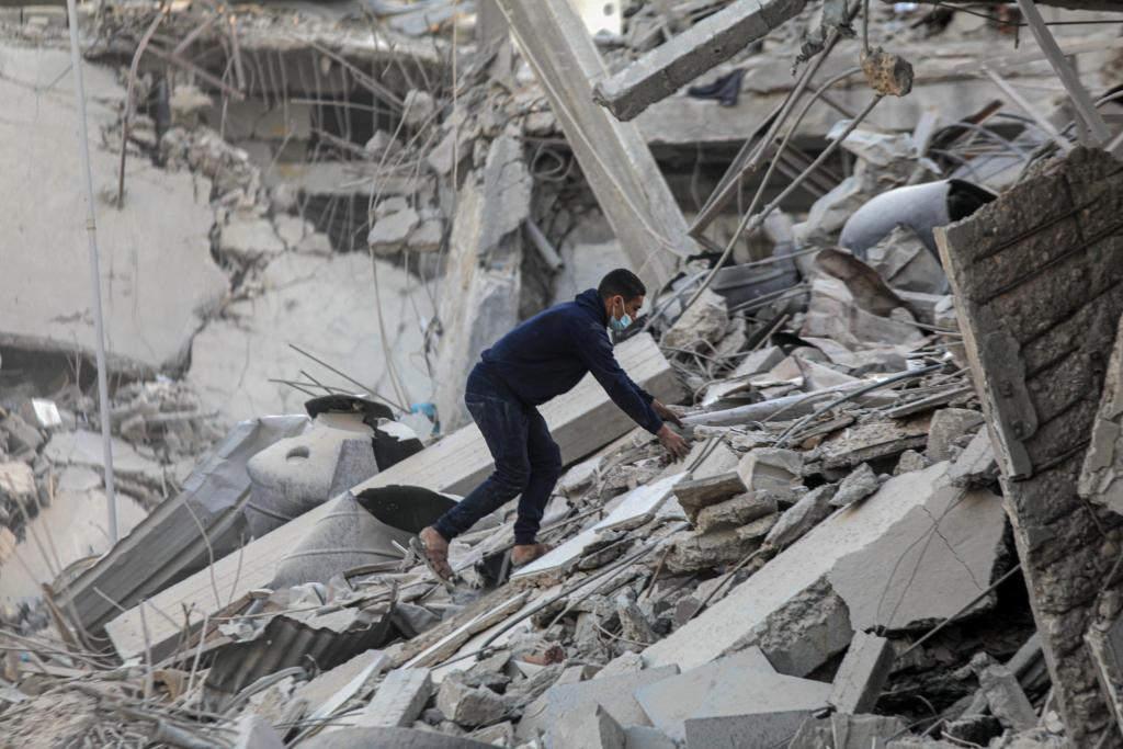 3月6日，在加沙地带南部城市汗尤尼斯，一名男子清理建筑废墟。新华社发（里泽克·阿卜杜勒贾瓦德摄）