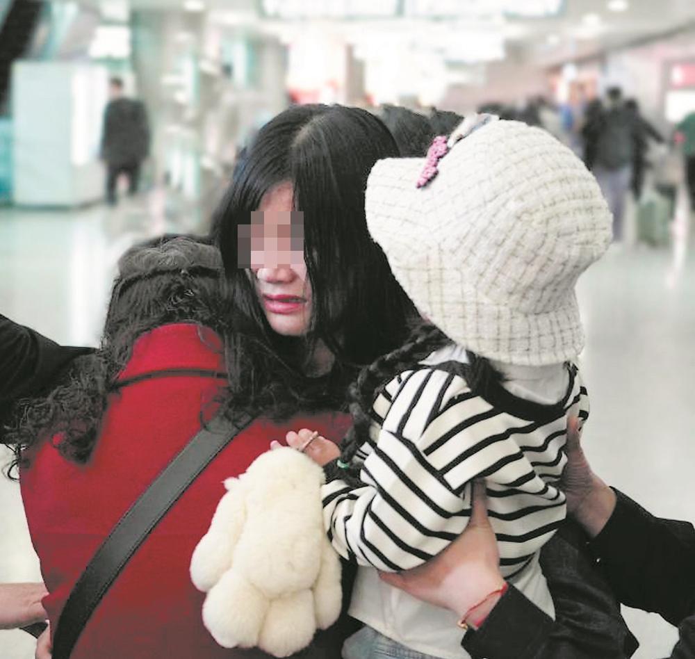 张娟（中）同生母在机场拥抱