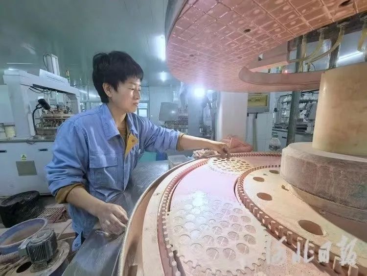 2023年12月28日，秦皇岛星箭特种玻璃有限公司工人正在对玻璃盖片进行抛光。河北日报记者孙也达摄