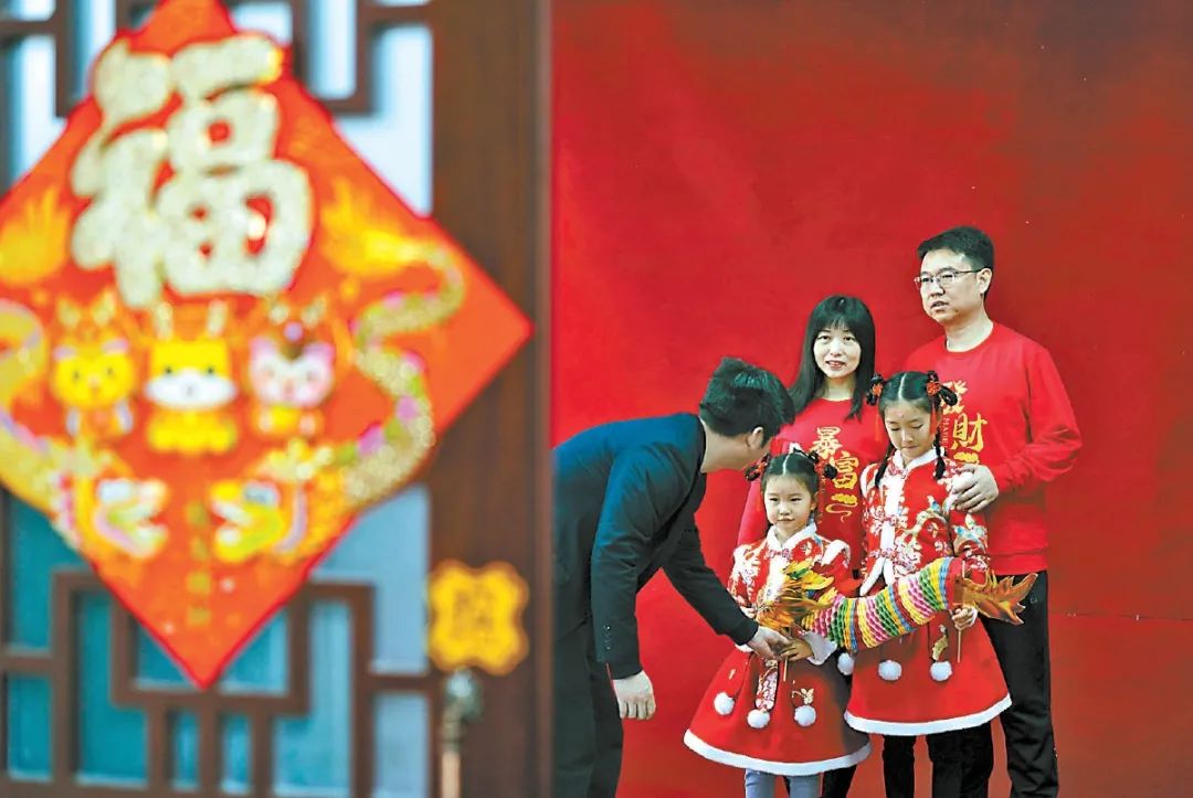 "在摄影师的指导下,随着"咔嚓"一声,闪光灯一闪而过,一张全家福拍摄