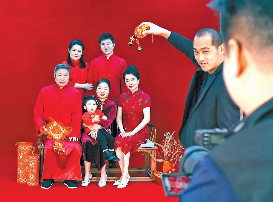 "在摄影师的指导下,随着"咔嚓"一声,闪光灯一闪而过,一张全家福拍摄