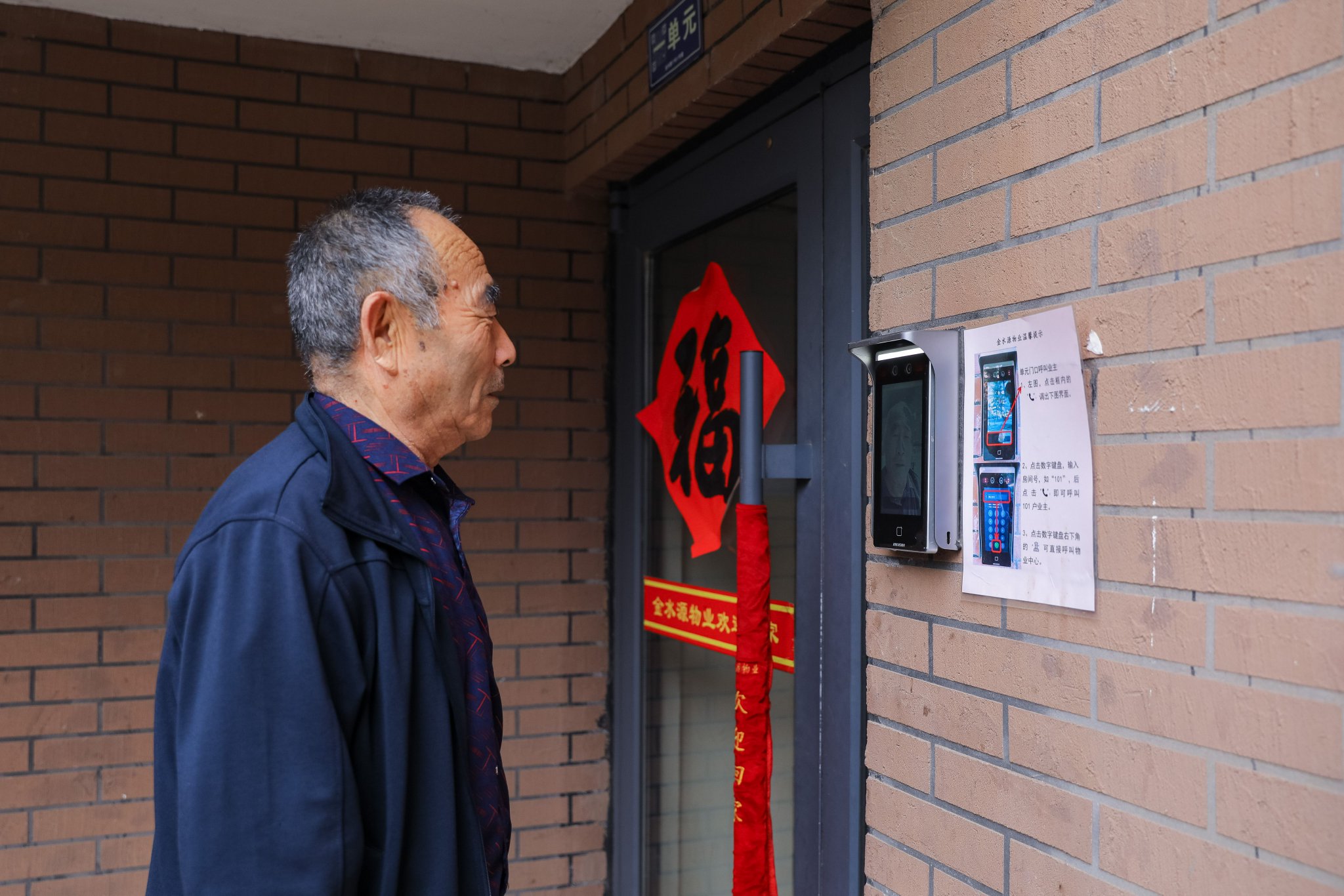 张鹰 摄4月2日,在青岛市李沧区世园街道上流佳苑社区,工作人员通过