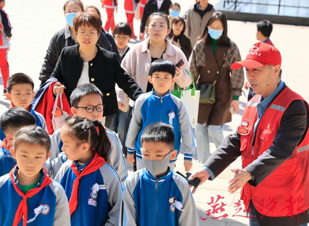 志愿者引导小学生入园缅怀先烈
