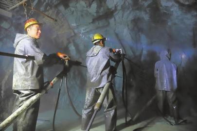 工人们在太和隧洞岩壁上钻孔作业。